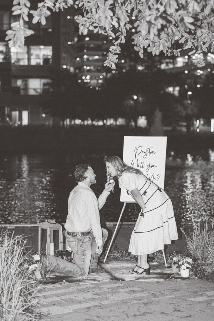 Couple sharing an intimate moment during surprise proposal at Hughes Landing 