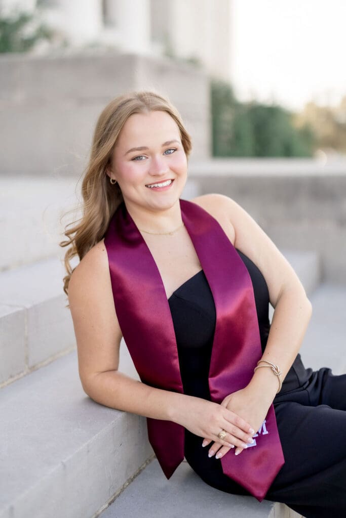 Grace posing at the Texas A&M Administration Building in her maroon stole