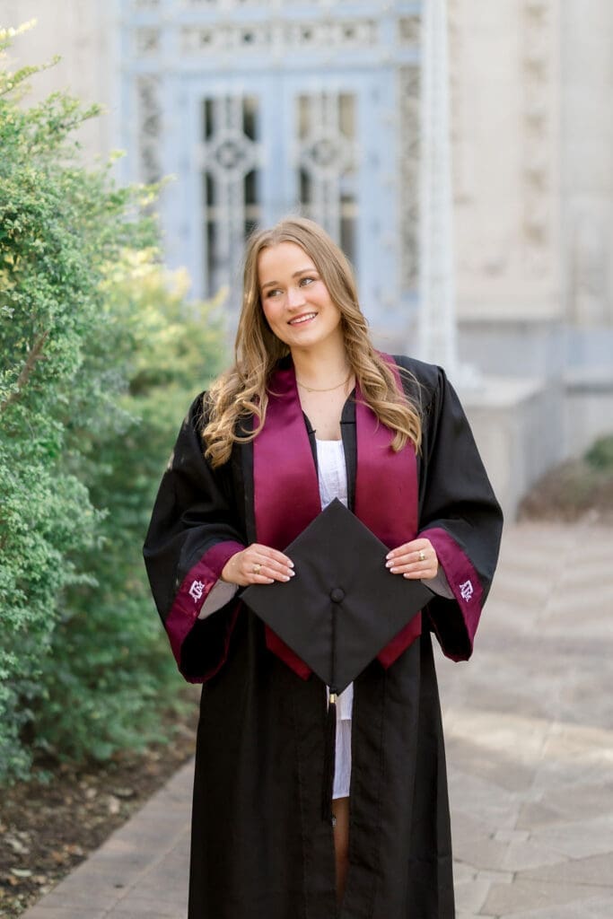 TAMU senior photos at Scoates Hall with Grace standing in front of the blue doors in a white dress