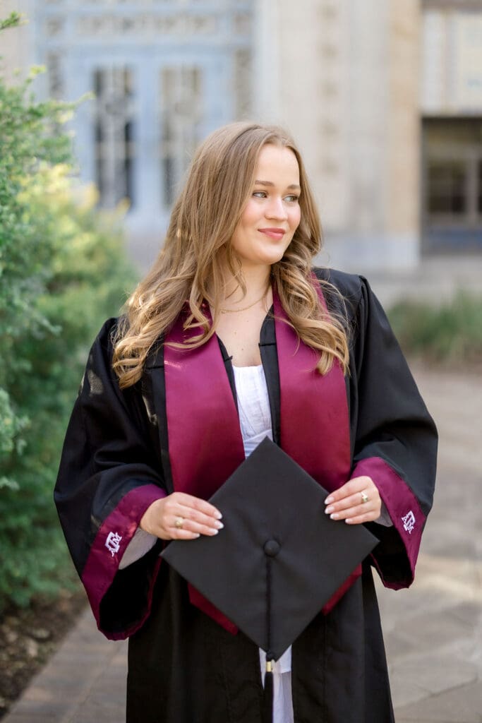 TAMU senior photos at Scoates Hall with Grace standing in front of the blue doors in a white dress