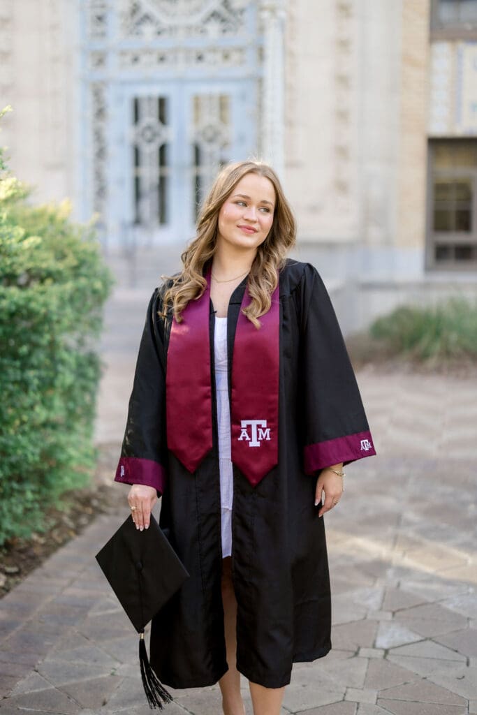 TAMU senior photos at Scoates Hall with Grace standing in front of the blue doors in a white dress