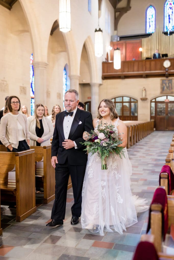 Bride Alexis walking down the aisle at Holy Rosary Catholic Church, captured by Texas Catholic wedding photographer