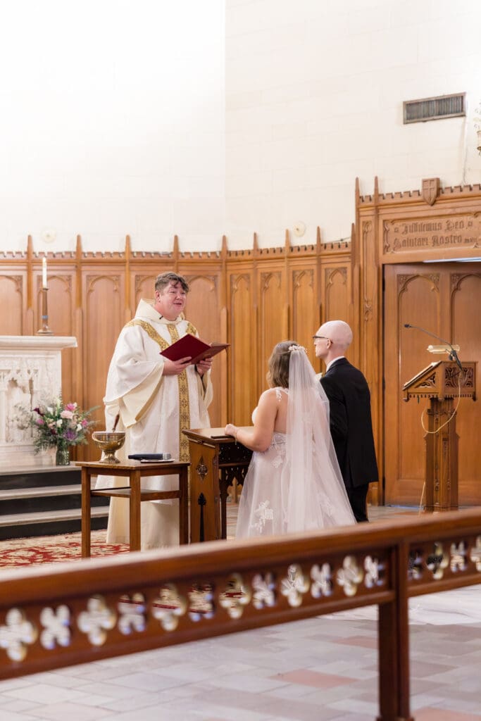 Bride and groom kneeling together at altar in Catholic wedding by Texas wedding photographer