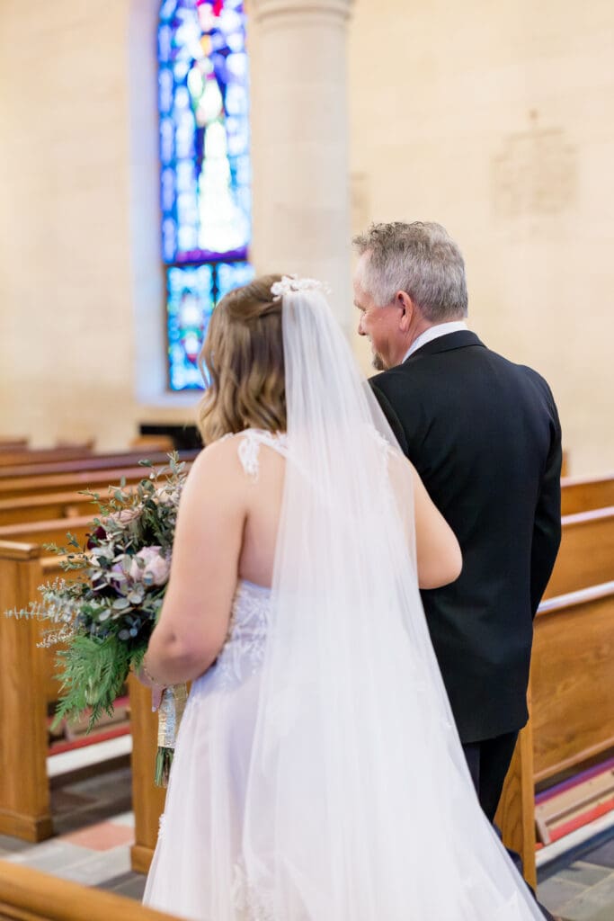 Bride Alexis walking down the aisle at Holy Rosary Catholic Church, captured by Texas Catholic wedding photographer