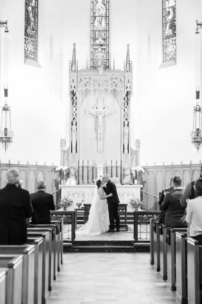 Groom Hunter waiting at altar during Catholic wedding ceremony in Texas