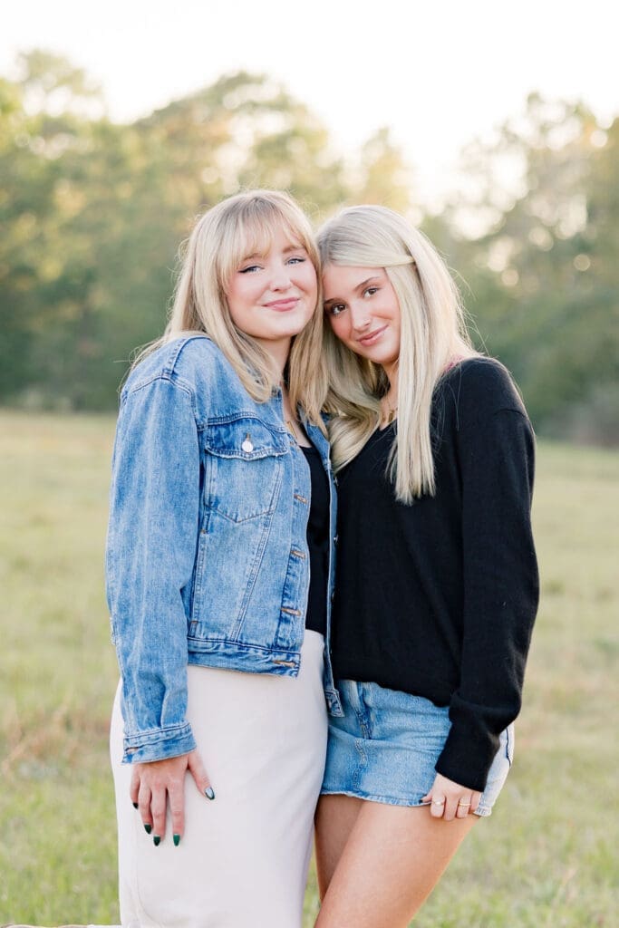 Family walking through grassy field at sunset in the woodlands capturing portraits