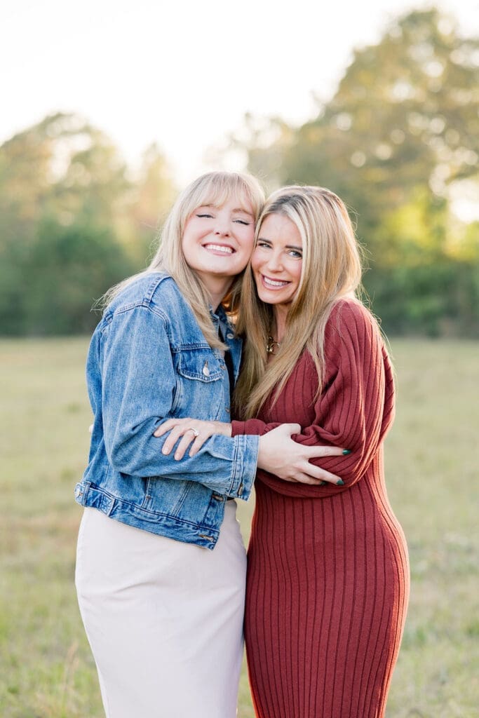 Family walking through grassy field at sunset in the woodlands capturing portraits