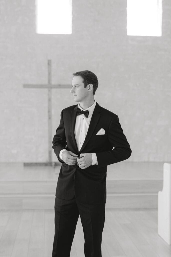 Groom adjusting his tie before the wedding ceremony 