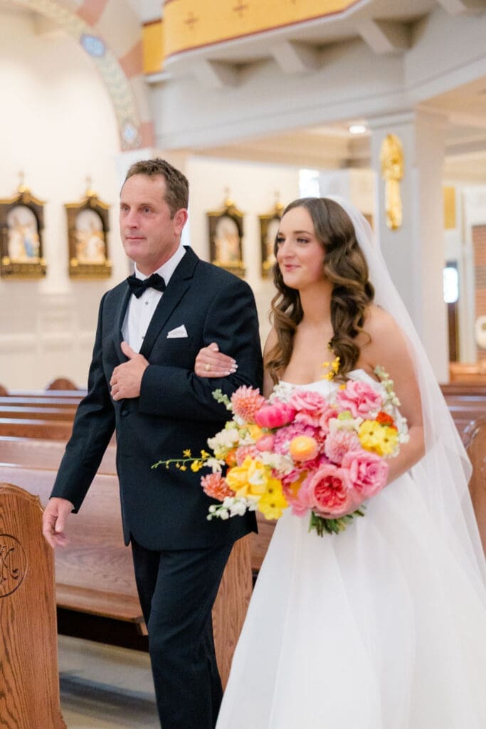 Catholic church wedding photographer Texas capturing bride walking down aisle